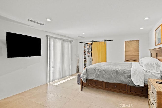 bedroom featuring light tile patterned flooring, a barn door, visible vents, and recessed lighting