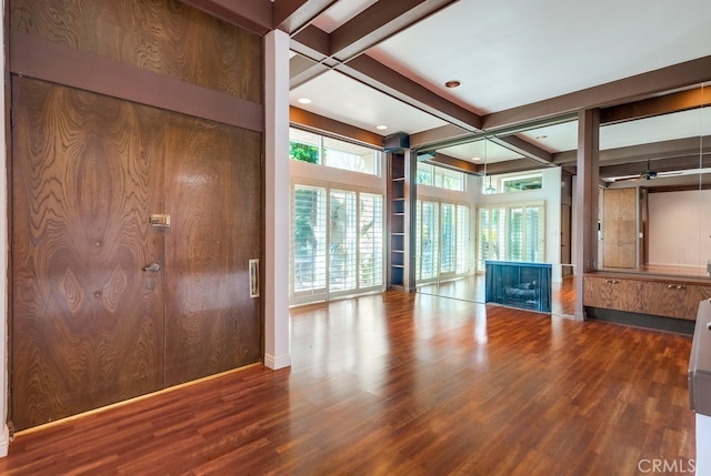 interior space with wooden walls, hardwood / wood-style floors, beamed ceiling, and coffered ceiling