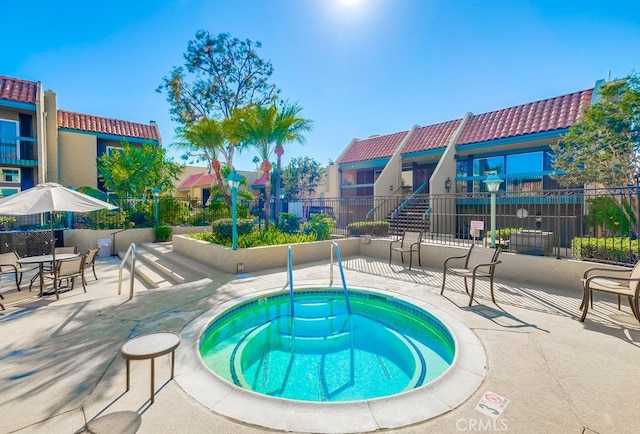 view of swimming pool featuring a patio area and a hot tub