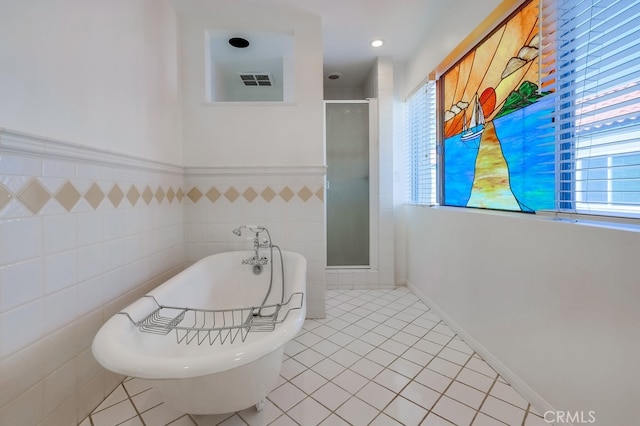 bathroom with tile patterned floors, separate shower and tub, and tile walls