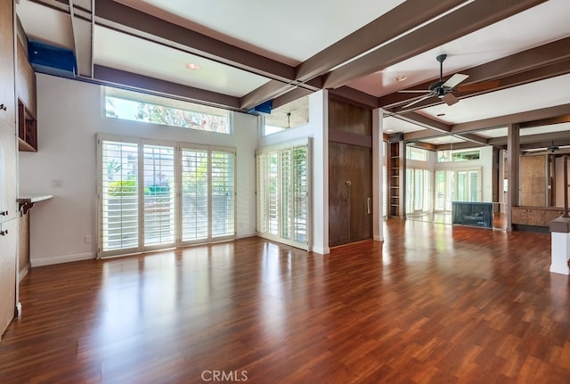 unfurnished living room with ceiling fan, beamed ceiling, and wood-type flooring