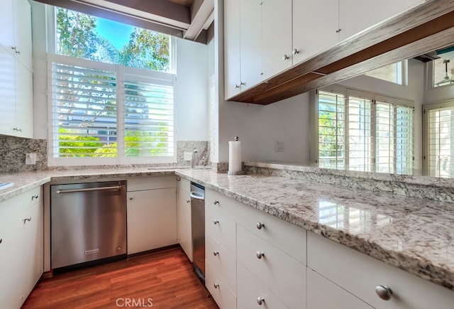 kitchen with decorative backsplash, white cabinetry, dark wood-type flooring, and stainless steel dishwasher