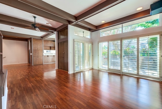 unfurnished living room featuring dark hardwood / wood-style flooring, ceiling fan, and a healthy amount of sunlight