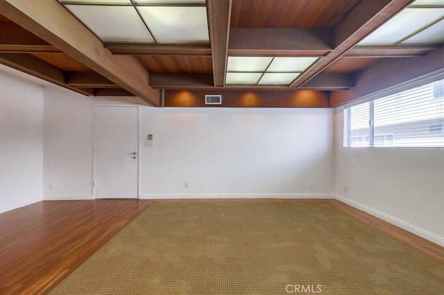 empty room with beamed ceiling and hardwood / wood-style floors