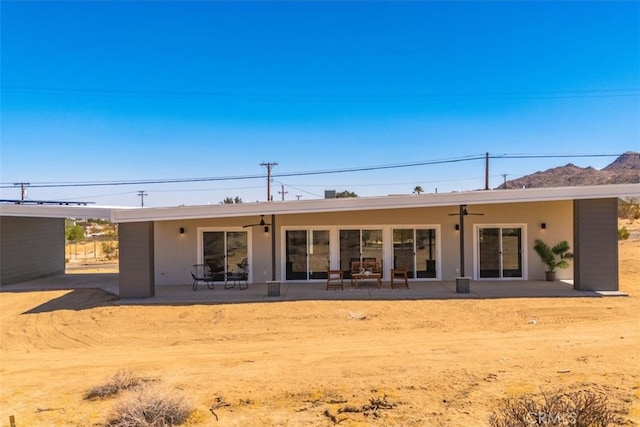 rear view of house with ceiling fan and a patio