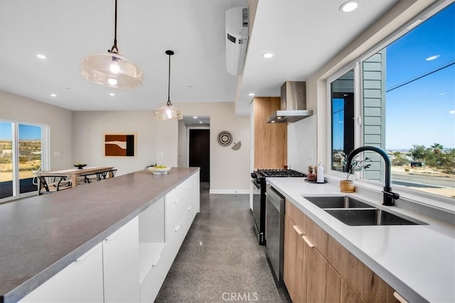 kitchen featuring appliances with stainless steel finishes, wall chimney exhaust hood, hanging light fixtures, and sink