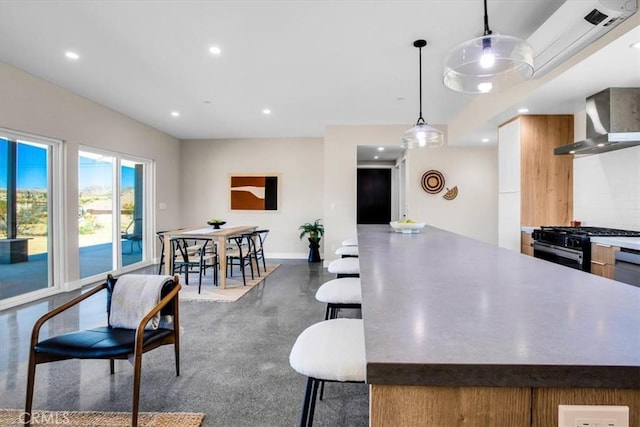 6614 Sunset Rd, Joshua Tree, CA 92252 - kitchen featuring wall chimney range hood, black range with gas stovetop, recessed lighting, baseboards, and pendant lighting