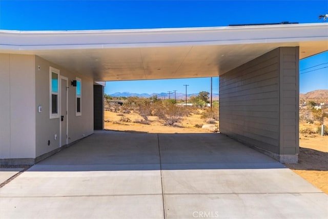 view of parking / parking lot featuring a carport and a mountain view