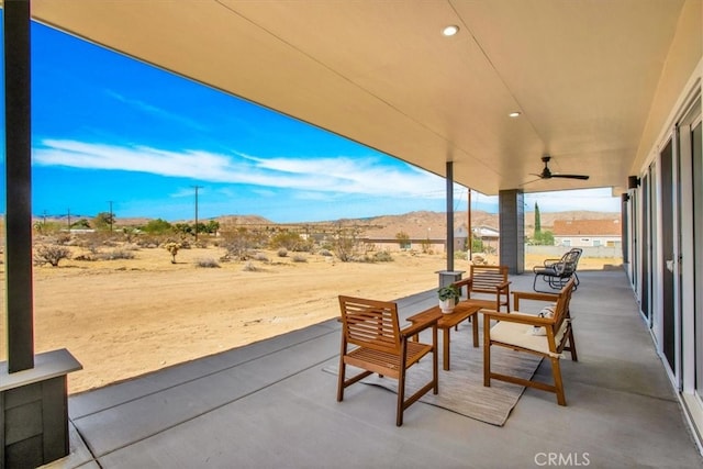 view of patio featuring ceiling fan and a mountain view