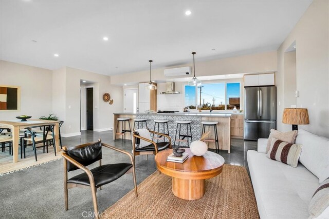 living room featuring sink and an AC wall unit