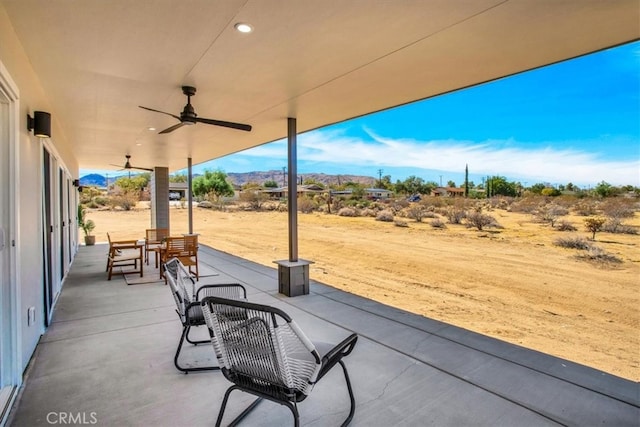 view of patio / terrace with ceiling fan and a mountain view