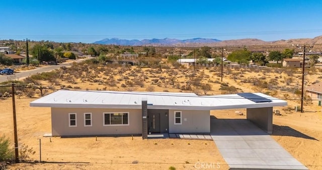 6614 Sunset Rd, Joshua Tree, CA 92252 - ranch-style home featuring a mountain view, concrete driveway, view of desert landscape, and an attached carport