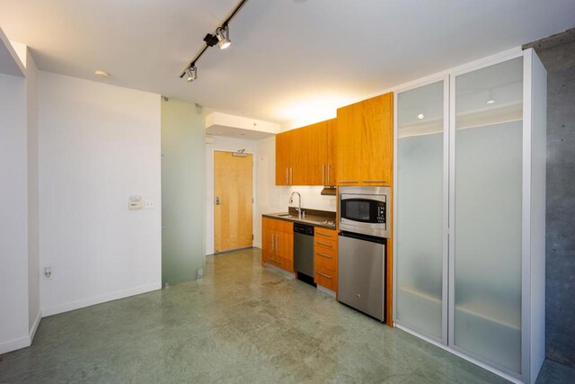 kitchen featuring appliances with stainless steel finishes, sink, and track lighting