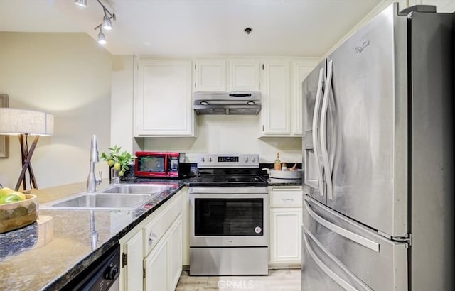 kitchen with appliances with stainless steel finishes, sink, dark stone counters, and white cabinets