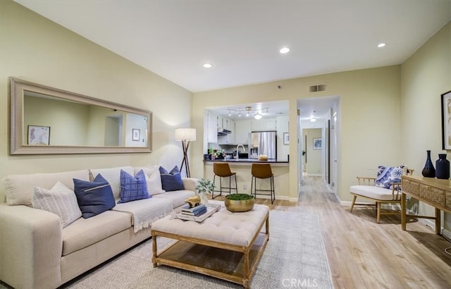 living area with recessed lighting, visible vents, baseboards, and light wood-style floors