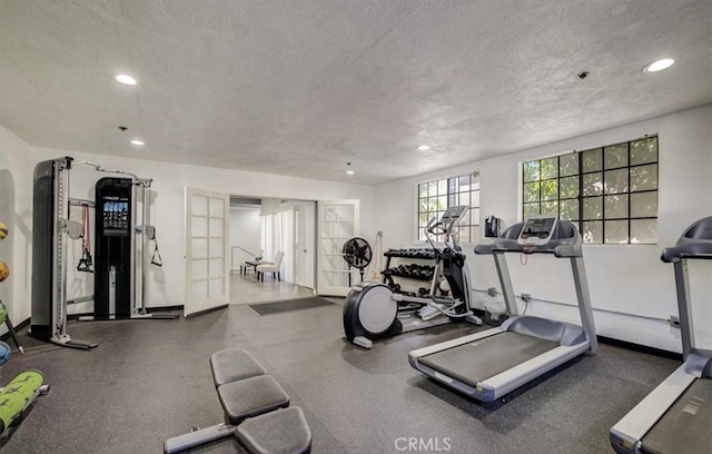 workout area with french doors and a textured ceiling