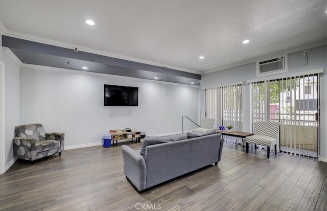 living room with baseboards, wood finished floors, ornamental molding, and a wall unit AC