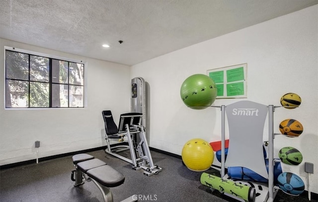 workout area with recessed lighting, a textured ceiling, and baseboards