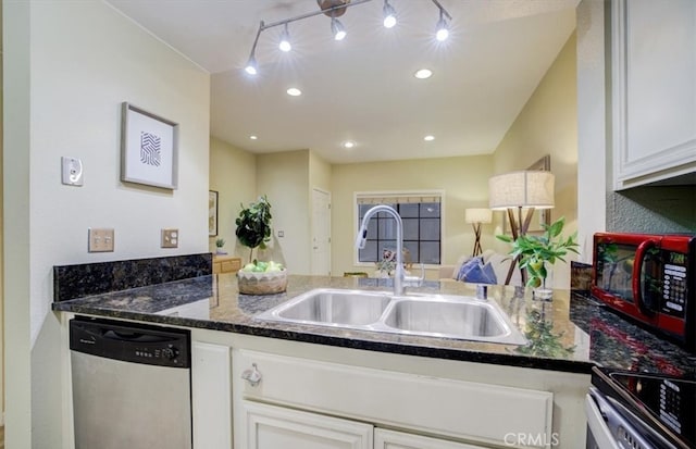 kitchen with sink, appliances with stainless steel finishes, kitchen peninsula, and white cabinetry