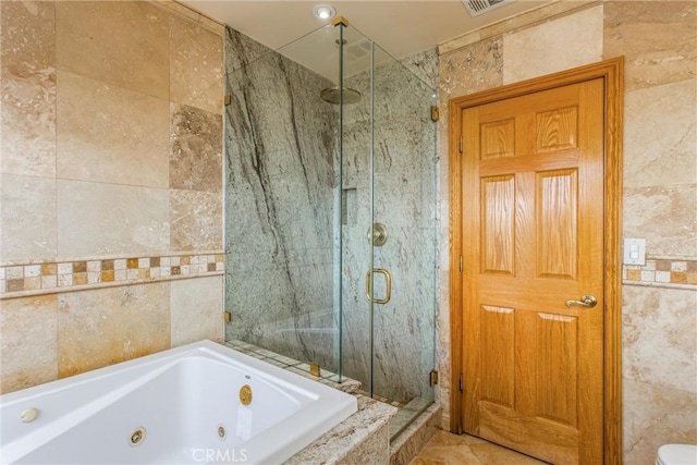 bathroom with shower with separate bathtub and tile walls