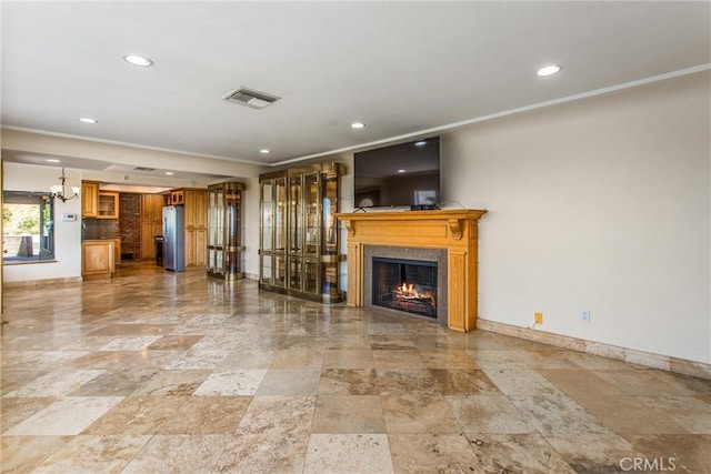 unfurnished living room featuring a chandelier and crown molding