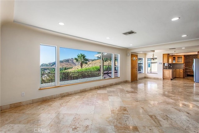 unfurnished living room featuring a mountain view and sink