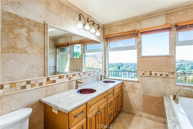 bathroom with vanity, a healthy amount of sunlight, and tile walls