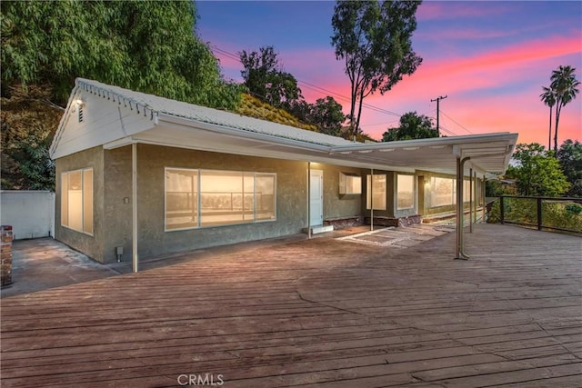 back house at dusk with a deck