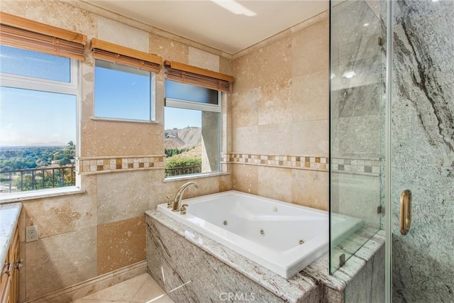 bathroom featuring shower with separate bathtub, vanity, and tile walls