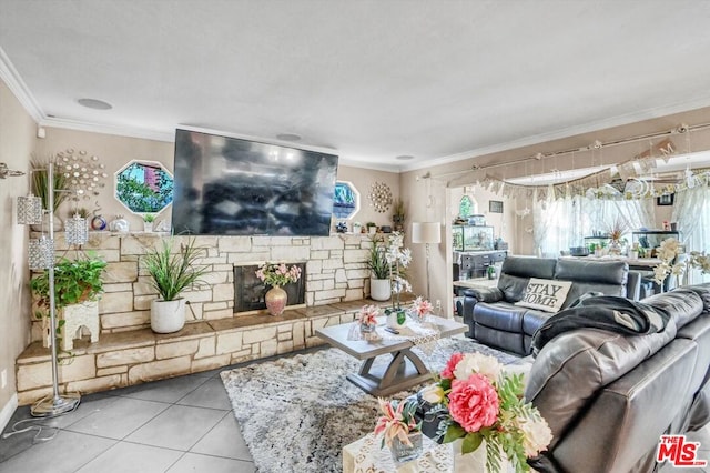 living room with crown molding, a stone fireplace, and light tile patterned flooring