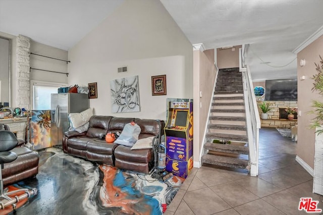 tiled living room featuring ornamental molding and high vaulted ceiling