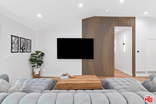 living room featuring light hardwood / wood-style floors and vaulted ceiling