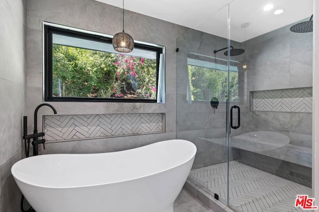 bathroom featuring tile patterned flooring, shower with separate bathtub, and tile walls