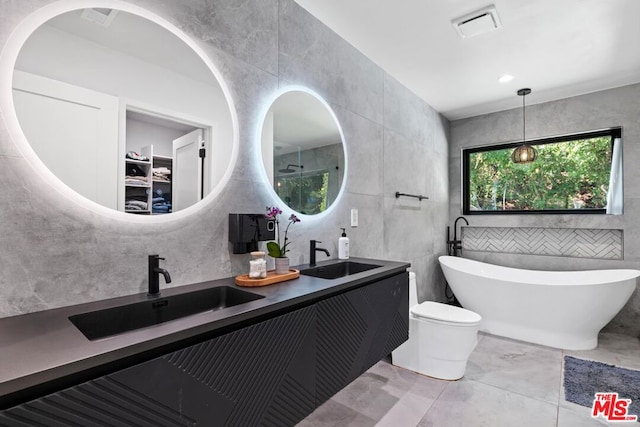 bathroom with toilet, a bathing tub, vanity, and tile walls