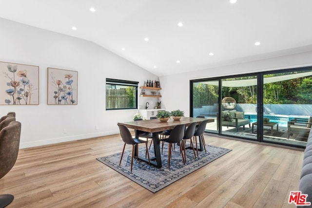 dining space featuring vaulted ceiling and light hardwood / wood-style floors