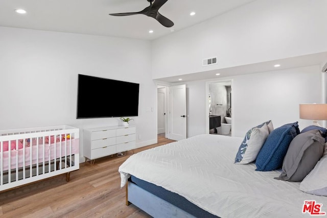 bedroom featuring high vaulted ceiling, ensuite bath, ceiling fan, and light hardwood / wood-style floors