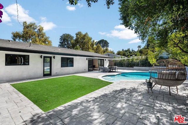 view of pool with a lawn and a patio area