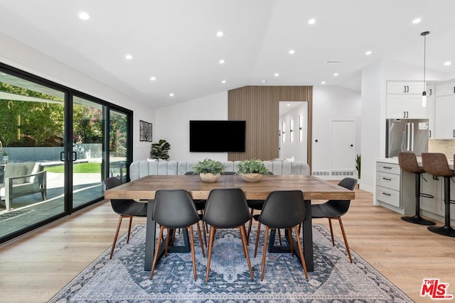 dining area featuring lofted ceiling and light hardwood / wood-style flooring