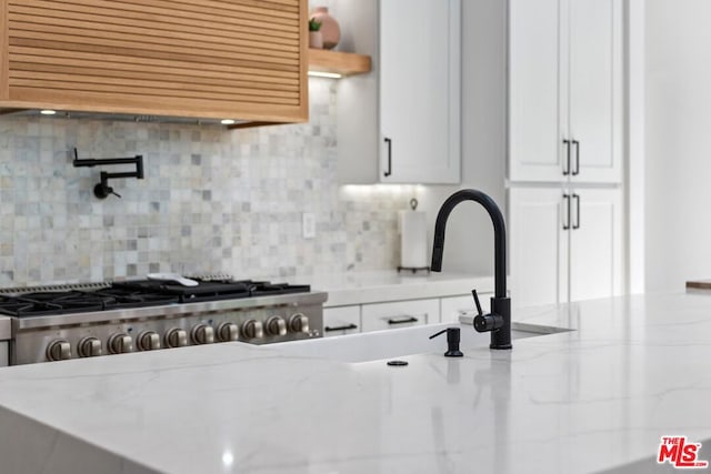 room details featuring decorative backsplash and light stone countertops