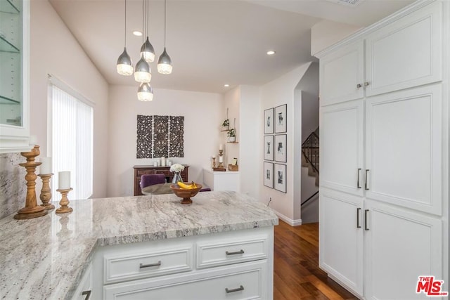 kitchen featuring white cabinetry, light stone counters, dark hardwood / wood-style flooring, and decorative light fixtures