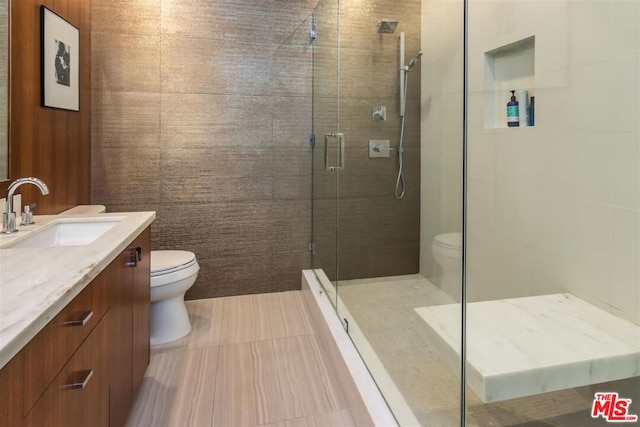 bathroom featuring vanity, walk in shower, and toilet