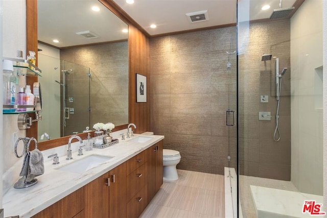 bathroom featuring vanity, a shower with door, and toilet