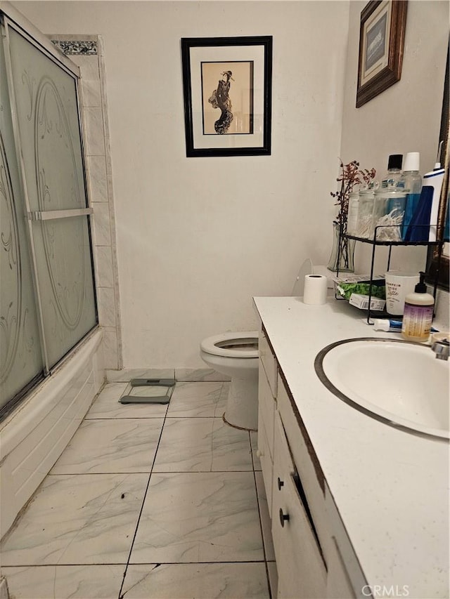 full bathroom featuring vanity, combined bath / shower with glass door, and toilet