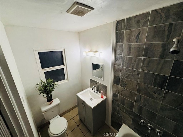 bathroom with tile patterned floors, a tub, vanity, and toilet