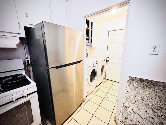 kitchen featuring gas range gas stove, separate washer and dryer, light tile patterned flooring, stainless steel fridge, and white cabinets