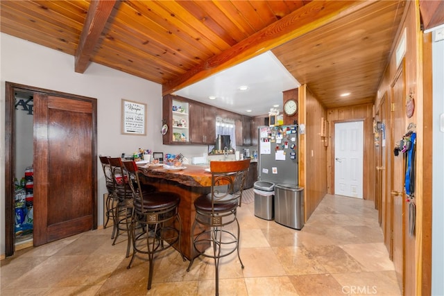 bar with wood ceiling, wood walls, beamed ceiling, and stainless steel fridge