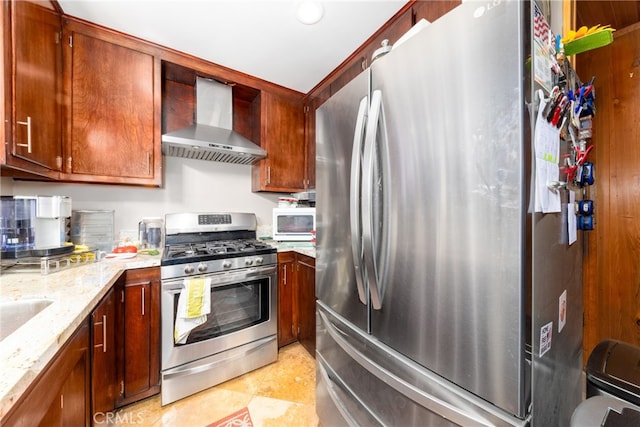 kitchen featuring light stone counters, stainless steel appliances, and wall chimney exhaust hood