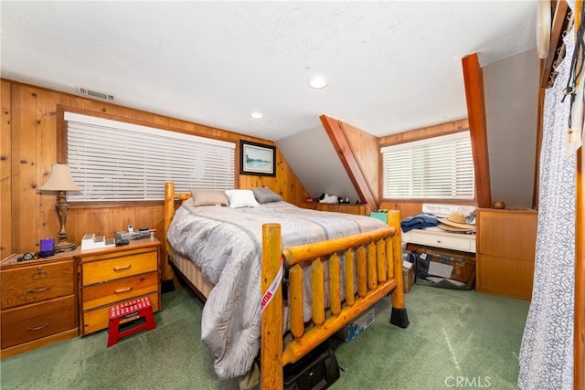 bedroom with dark carpet, lofted ceiling, and wood walls