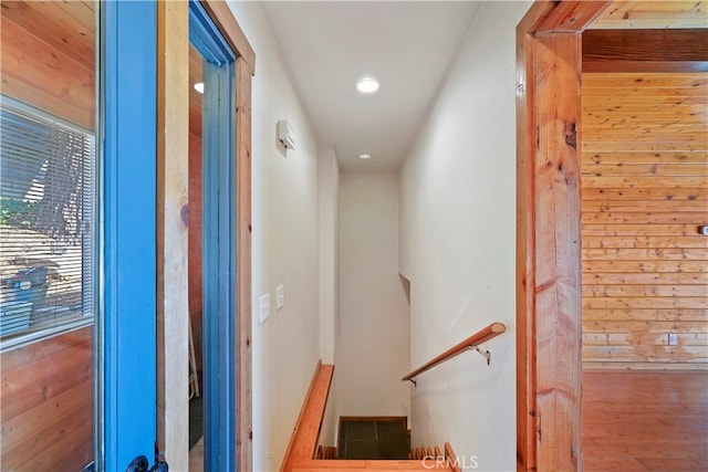 stairway featuring wooden walls and hardwood / wood-style floors