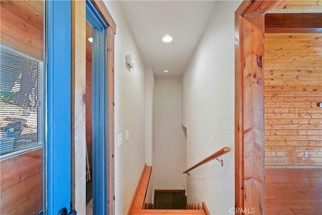 staircase featuring wooden walls and wood finished floors